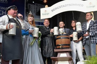 Freiberg startet in den Bergstadtsommer - Mit nur einem Schlag hat Thomas Mielenz (links) alias Braumeister Michael am Donnerstagabend zur Eröffnung des Bergstadtsommers das Fassbier angestochen. Mit auf der Bühne standen Silberstadtkönigin Julia Richter, Oberbürgermeister Sven Krüger, Holger Scheich vom Freiberger Brauhaus, Anja Fiedler als Leiterin des Amtes für Kultur-Stadt-Marketing und Frank Rehagel, ebenfalls vom Brauhaus (von links). 