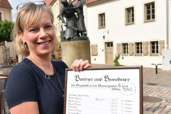 Freiberg: Wohnhaus Untergasse 4 mit Sanierungspreis ausgezeichnet - Diana Mader-Schumann, hier mit einer Liste der Inhaber und Bewohner des Hauses Untergasse 4, freut sich mit ihrem Mann Janek über den Sanierungspreis.