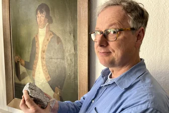 Freiberger Geologen entdecken ein Stück Afrika in Bulgarien - Professor Thorsten Nagel mit einer Gesteinsprobe aus Bulgarien. Das Gemälde im Hintergrund zeigt Alexander von Humboldt.