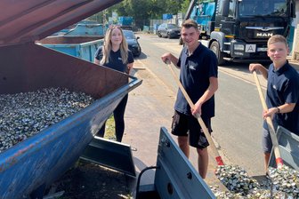 Freiberger Kronkorken-Sammelaktion: Jugendclub bringt 140 Kilo vorbei - Mitglieder des Zuger Jugendclubs schaufeln Kronkorken vom Anhänger in den Container.