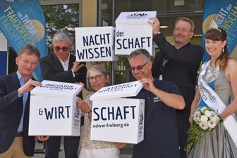 Freiberger Schlossplatz wird zur großen Freiluft-Experimentierfläche - Staatssekretärin Andrea Franke (3. von links), Dr. Gunter Erfurt (vorn links), Chef der Meyer Burger Technology AG, Rektor der TU Bergakademie Professor Klaus-Dieter Barbknecht (2. von links), Oberbürgermeister Sven Krüger(2. von rechts), Professor Dr. Jens Gutzmer (3. von rechts) Direktor Helmholtz-Institut Freiberg für Ressourcentechnologie und die Silberstadtkönigin Julia (rechts) setzten den Logo-Würfel zusammen. 