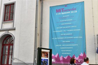 Freiberger Theater startet in besondere Spielzeit - Die beiden neuen Spielzeit-Banner am Freiberger Theater am Buttermarkt - hier das rechte - künden davon: Im Mittelsächsischen Theater beginnt eine neue Spielzeit - mit neuem Programm, neuen Farben, neuen Namen und neuem Logo. 