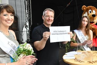 Freiberger und ihre Gäste feiern ausgelassen - Die scheidende Silberstadtkönigin Julia I. (l.), ihre Nachfolgerin Celine I. und Oberbürgermeister Sven Krüger losen den Gewinner der Vereinstombola aus.