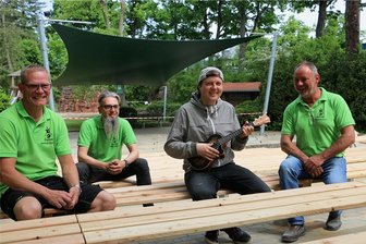 Freilichtbühne Syrau aufgepeppt: Probesitzen auf neuen Bänken für das Juniton-Festival - Thomas Wagner, Mario Branse, Musiker Christian Wenzel und Falk Zeh (von links), Vorsitzender vom Syrauer Dorfclub-Verein, auf den neuen Sitzbänken der Freilichtbühne.
