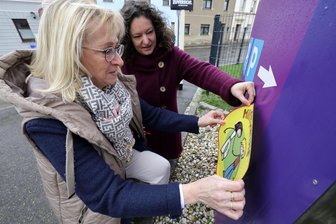 Fremde sprechen Kinder an: Schon neun Fälle in sechs Monaten in Glauchau – Diakonie reagiert mit „Hilfepunkt“ - Katrin Resch vom Jugendamt (vorn) und Carolin Hummel bringen den Aufkleber „Hilfepunkt“ am Haus der Diakonie in Glauchau an.
