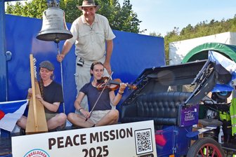 Friedensglocke aus Militärschrott passiert das Erzgebirge: Was es mit der Aktion auf sich hat - Friedensglocken-Treck auf Probefahrt durchs Erzgebirge: Karl-Dietmar Plentz betätigt eine Friedensglocke, begleitet von den Musikerinnen Hanna Schnittger mit einer keltischen Harfe und Merle Gertsen mit einer Violine.