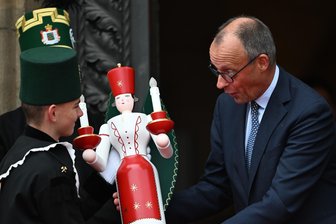 Friedrich Merz auf Antrittsbesuch in Sachsen: Zwischen Handwerk und Hightech - Bundeskanzler Friedrich Merz (r.) erhielt bei seiner Ankunft vor der Staatskanzlei die traditionellen erzgebirgischen Holzfiguren Bergmann und Engel.