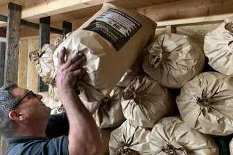 Frische Holzkohle aus Sosa begeistert Grillfans - Erik Krauss stapelt die in Säcken gepackte Holzkohle.