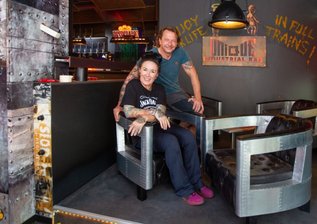 Frischer Wind in Gastro-Szene: Bar entsteht in Industriedesign - Caroline Pflug und Michael Baumgärtel in ihrer neuen Bar Unique. Links im Hintergrund sieht man den grünlich leuchtenden Wasserfall über der Theke. 