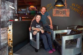 Frischer Wind in Plauener Gastro-Szene: Neue Bar entsteht in Industriedesign - Caroline Pflug und Michael Baumgärtel in ihrer neuen Bar Unique. Links im Hintergrund sieht man den grünlich leuchtenden Wasserfall über der Theke.