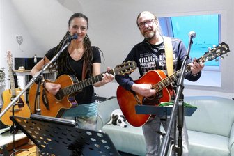 Fünf Jahre Real Music: Wenn ein Venusberger Wohnzimmer zum Tonstudio wird - Während sich ihr Hund Maggie auf dem Sofa ausruht, spielen Nadine Winterstein und Andreas Mann Gitarre. Für das Paar aus Venusberg ist das Wohnzimmer zugleich sein Proberaum und Tonstudio.