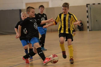 Fußballnachwuchs misst sich in der Halle: Lindenauer Turnier dient dem Gastgeber als Aushängeschild - Beim Lindenauer Budenzauber jagte auch die F-Jugend dem runden Leder nach. Hier ist Emil Westenburger (l.) vom gastgebenden SV Lindenau am Ball. Chris Hymek vom FC Concordia Schneeberg eilt dazu.