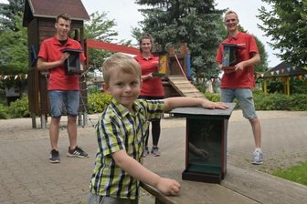 Futterhäuschen aus Holzabfällen - Eric Lindner, Svenja Liebold und Moritz Walther (hinten v. li.) haben die Futterhäuschen ins Kinderhaus Neustädtel gebracht, wo auch der dreijährige Jarne Oster betreut wird.