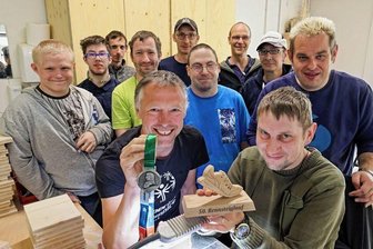 Gänsehautmoment für einen Ausdauersportler - Dirk Lupke (vorn links) wurde nach dem Rennsteiglauf von seinen Kollegen mit einer selbst gefertigten Trophäe überrascht. Marcel Schuhmann (rechts) hat das Teil mit der Laubsäge ausgesägt.