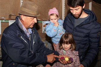 Gäste tauchen in Rotschau in Kartoffelvielfalt ein - So farbenfroh kann Kartoffelgenuss sein: Ulrich Gündel (links) zeigt Florian Preuß und den Kindern Nora und Thea, wie man Abwechslung auf den Teller bringt. 