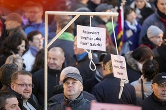 Galgenbauer hält seine Botschaft für Satire - Das Corpus Delicti und sein Erbauer: Jens D. (mit Brille) hat eingeräumt, den für Angela Merkel und Sigmar Gabriel reservierten Galgen gezimmert und zur Demonstration präsentiert zu haben.