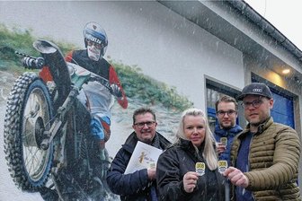 Gedenken an Gelenauer Endurosportler: Startnummer 308 bringt weiterhin Glück - Vor einem Wandbild, das ihren Vater in Aktion zeigt, übergaben Yannic und Eric Cyffka ihre Spende sowie einige Sticker an Daniela Lieberwirth und Christian Frank (v. r.) vom Chemnitzer Lukas-Stern-Verein.