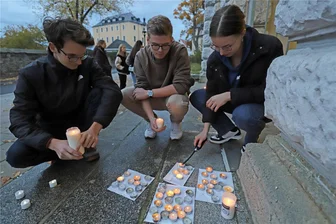 Gedenken an Reichspogromnacht: Wo in Freiberg Lichtpunkte aufleuchten - Die Schüler Lennard Roth, Nico Noack und Jana Vogler entzünden Kerzen am Geschwister-Scholl-Gymnasium.
