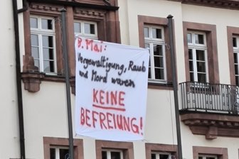 Gedenken zum 8. Mai gestört: Polizei ermittelt wegen Bannern im Raum Leisnig - Dieses Banner aus Stoff hing am Donnerstag an Fahnenmasten vor dem Rathaus Leisnig.