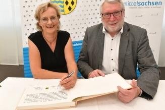 Geehrte tragen sich in Goldenes Buch ein - Die Erlauerin Jana Ahnert trug sich ins Goldene Buch ein, hier mit Landrat Matthias Damm.