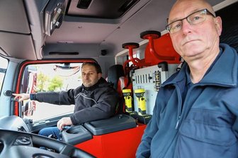 Gefahr in der Kurve: Feuerwehr Schönheide rüstet Abbiegeassistenten nach - René Schwotzer (rechts) ist Wehrleiter der Schönheider Feuerwehr. Er sitzt mit Marcus Hoffmann von der Firma Oppel im Fahrerhaus des Löschgruppenfahrzeugs, das mit dem Abbiegeassistenten ausgestattet wurde.