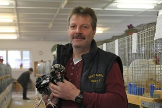 Geflügelschau im Erzgebirge: Nur Tauben von hier dürfen gezeigt werden - Mike Kunstmann, der Ausstellungsleiter des Rassegeflügelzüchtervereins Zwönitz von 1862, mit seinem prämierten Zwerg-Houdan schwarz-weißgescheckt. Hühner und Wassergeflügel dürfen derzeit bei Tierschauen allerdings nicht gezeigt werden. 