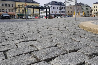 Gegen Stolperfallen: Marktplatz Oelsnitz wird gesandet - Tiefe Zwischenräume zwischen den Pflastersteinen am Markt gibt es vor allem an der Ecke Dr.-Külz-/Marktstraße.
