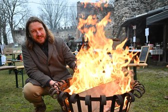 Geheime Treppen und dicke Mauern: Was Besucher der Schlossruine Hartenstein am Samstag zu sehen bekamen - Legt noch mal Holz in die Feuerschale nach: Sebastian Hessel, Vorsitzender des Vereins Schlossruine Hartenstein.