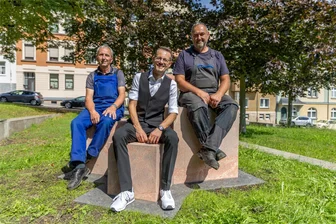Geheimnis gelüftet: Siegelohplatz Auerbach wird mathematisch-physikalischer Freiluft-Salon - Die sogenannte Pythagoreische Sitzgruppe veranschaulicht den Satz des Pythagoras. Auf den drei Würfeln aus Rochlitzer Porphyr Platz genommen haben Ideengeber Kay Herrmann (vorn) sowie die Erbauer der Sitzgruppe und des Hyper-Würfels, Dietrich Roßbach (links) und Andreas Kölbel (rechts).