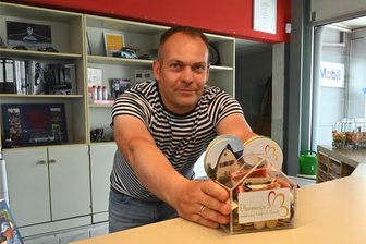 Geklaute Spendenbox für krebskranke Kinder: Stündlich neue Spenden in Frankenberg - Matthias Haferkorn zeigt die neue, schon gut gefüllte Spendenbox in seinem Kfz-Service in Frankenberg.