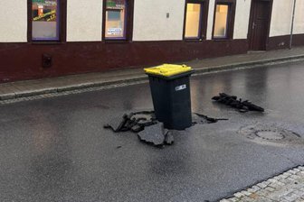 Gelbe Tonne im Loch der Straße ein cleveres Signal - Straße wegen Reparatur bis 24. Juni voll gesperrt - Unwetter vom Sonntag: Die Tonne in der Straße war ein cleveres Warnsignal für Kraftfahrer. Foto: Peter Firlei Foto: Peter Firlei
