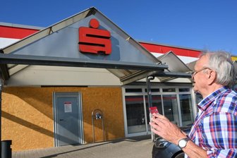 Geldautomat gesprengt: Wer Geld abheben will, muss Umwege in Kauf nehmen - Helmut Werner steht vor der geschlossenen Filiale der Sparkasse Mittelsachsen im Olipark. Seit der Bankautomatkaputt ist, muss er große Umwege zum Geldabheben fahren. Das ärgert nicht nur ihn. 