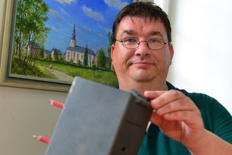 Gemeinde appelliert an dreiste Diebe - Kirchenvorsteher Michael Kreskowsky zeigt im Vorraum der Kirche in Grünlichtenberg die wieder aufgetauchte Spendenbox. Sie war dort am 31. August aus der Wand gerissen worden.