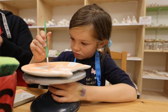 Gemeinsam kreativ sein und dabei entspannen: Das Erfolgskonzept von „Made by you“ in Zwickau - Volle Konzentration im Blick: Die sechsjährige Lotte bemalt einen Kitty-Cat-Teller. Das ist nur eine von über 300 Rohlingsformen, die im „Made by you“ an der Zwickauer Kreisigstraße zur Auswahl stehen.