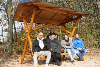 Gemeinschaftsprojekt bringt neue Bank in Flöhas Pfarrwald - Probesitzen auf der neuen Bank: Ronny Schneider, Katja-Doris Hauser, Alexander Peuckert und Ronny Hanke, (v.l.), hinten Gunter Lindner.