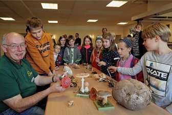Generationen-Uni lehrt: Kinder lieben Pilze - aber nicht auf dem Teller - Pilzberater Achim Heimer (links) war bei der Generationen-Uni im Schützenhaus zu Gast. Die Präsentation der Pilze hat die Kinder besonders begeistert. Rechts vorn ein zwei Jahre alter Riesenbovist.