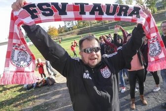 Generationswechsel bringt frischen Wind in Verein - Vize-Vereins-Chef Marcel Jähn und Fans vom FSV Taura bei einem Spiel der Mannschaft auf dem Fußballplatz in Taura.