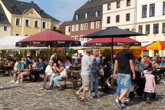 Genussmarkt lockt viele Besucher an - Unterm Sonnenschirm sitzen, genießen und sich unterhalten.