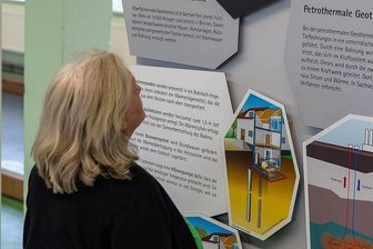 Geothermie in Sachsen: Schau in Grünbach wirft Schlaglicht - Kispileiterin Maria Faldum vor einem der Plakate in der Ausstellung "Sachsen hebt seine Schätze". Geophysiker Gerd Wolf weist darauf hin, dass Tiefengeothermie und Geothermie unterschiedliche Verfahren sind.