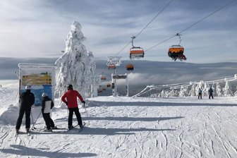 Gerichtsurteil zum Keilberg: Erweiterung des größten Skigebiets im Erzgebirge war illegal - Skifahrer an einem Pistenplan an der Südseite des Keilberg-Gipfels. Nach rechts zweigt hier die Strecke 24 ab - die Verbindung zum Skigebiet Neklid.