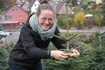 Geringswalde: Gärtnerei lädt zu „Weihnachtsträumerei“ - Jenny Horn vom Gartenbaubetrieb Horn markiert schon mal den von einer Kundin ausgewählten Weihnachtsbaum.