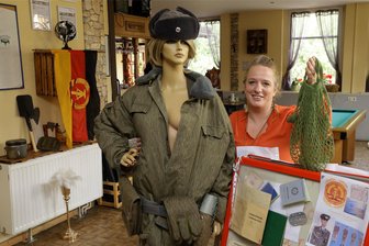 Gersdorf: Letzte Kneipe lädt zur ersten Ossi-Party - Wirtin Manuela Löbner-Lindner mit „NVA-Model“, Einkaufsnetz und anderen ostalgischen Utensilien: Am 28. September lädt das Gambrinus zur Ossi-Party nach Gersdorf.