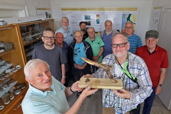 Geschenk für die Mineraliensammlung Reichenbach - Michael Schnabel (vorn rechts) dankt Thomas Grüner mit einem Geschenk.