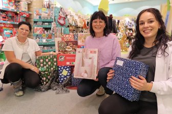 Geschenke im Schuhkarton sorgen in Werdau für Weihnachtsfreude - Cordula Gerth (li.) und Angelique Kaiser (re.) vom DM-Markt überreichten Bianca Lenk hübsch verpackte Schuhkartons.