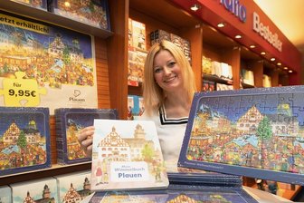 Geschenkideen zu Weihnachten: Vogtland-Präsente auf den letzten Drücker - Sophie Gürtler vom Plauener Dachverband Stadtmarketing mit dem beliebten Wimmelpuzzle und seinem "Vorgänger", dem Wimmelbuch. Der Spaß ist was für kleine und große Kinder.