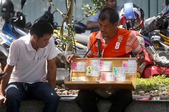 Glück mit Sarg Nummer 391: Thailänder feiern Lottogewinn - Ein Lotto-Verkäufer in Bangkok (Symbolfoto).