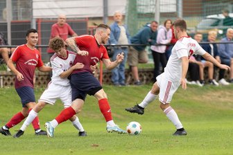 Glücklicher Punktgewinn für Langenauer Fußballer im Nachbarschaftsduell - Im Derby wurde sich nichts geschenkt: Hier versucht der Langenauer Jonas Hegewald (l.) TSV-Spieler Lucas Kaeselitz (M.) mit allen Mitteln zu stoppen.