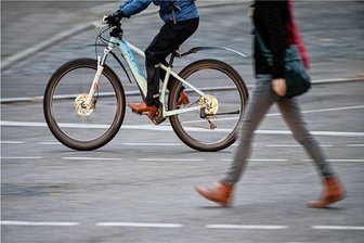 GPS-Tracker weist auf E-Bike-Dieb hin - Ein E-Bike-Fahrer und eine Fußgängerin sind im Stadtverkehr unterwegs (Symbolbild). Foto: Sebastian Gollnow/dpa/Archiv