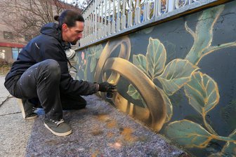 Graue Wand vor dem Zwickauer Standesamt wurde neu gestaltet: Eheringe gibt es jetzt schon vor dem Ja-Wort – zum Ansehen - Große Eheringe und Blumen hat Tobias Förster als Motiv für die Wand vor dem Standesamt ausgewählt.