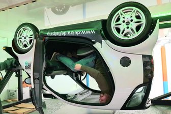Grenzerfahrung im Überschlagsimulator - Vogtländer testen ihre Fähigkeiten: „Das ist schon krass“ - Patrick Knoll sucht sich in dem testweise verunfallten Auto einen Weg nach draußen.